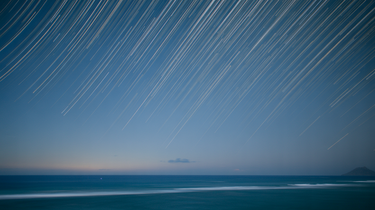 Long exposure photograph of star trails circling above Hawaiian horizon, illustrating the predictable movement of celestial bodies used in wayfinding
